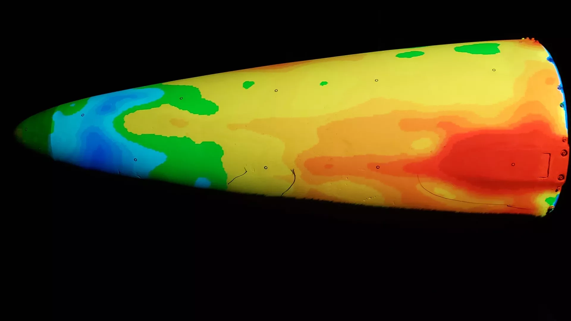 An automated inspection system, using metrology, projects a color-devatied map on a missile shroud to determine high and low spots.